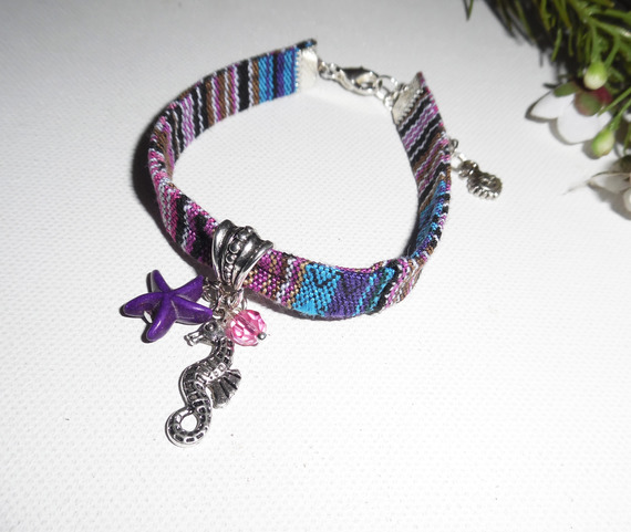 Colorful fabric bracelet with seahorse and purple starfish tassels