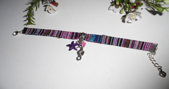 Colorful fabric bracelet with seahorse and purple starfish tassels