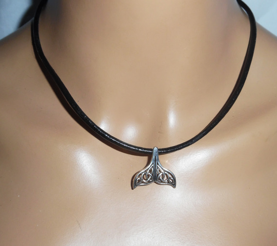 Pendant openwork dolphin tail lucky metal on black leather