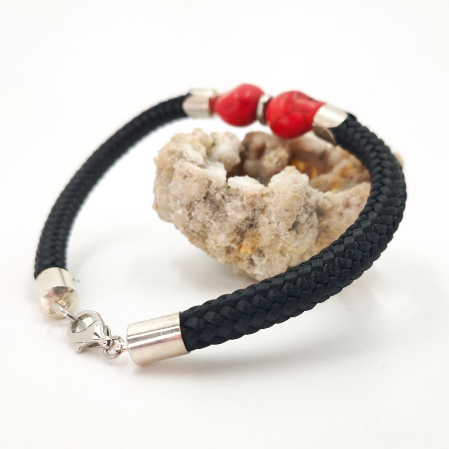 Double skull and crossbones bracelet with red stones on black rope