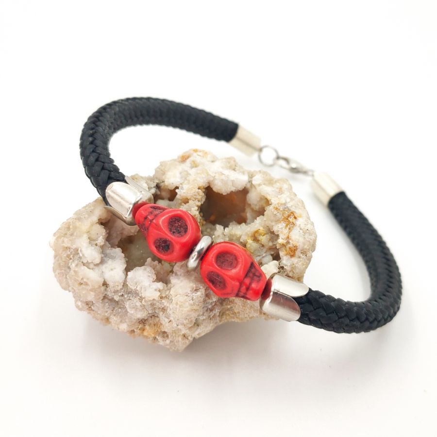 Double skull and crossbones bracelet with red stones on black rope