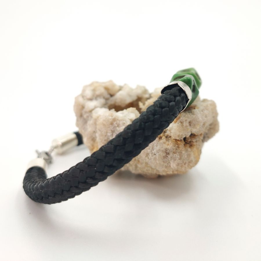 Double skull and crossbones bracelet with green stones on black rope